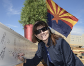 Leigh A. Neumayer, interim senior vice president for health sciences, adds her signature to the steel beam. (Kris Hanning/UAHS BioCommunications)